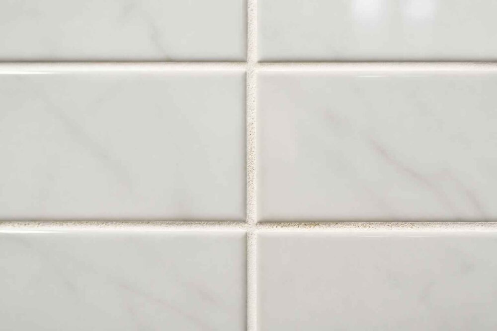 Zbliżenie białych prostokątnych płytek ceramicznych z jasnymi fugami
