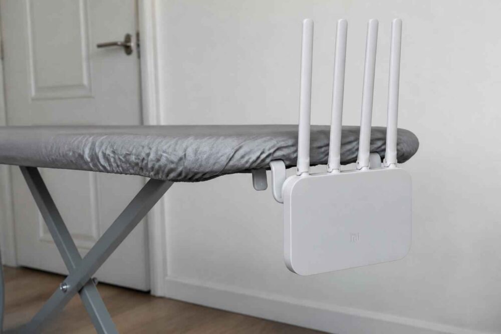 Biały router Wi-Fi z czterema antenami przymocowany do deski do prasowania